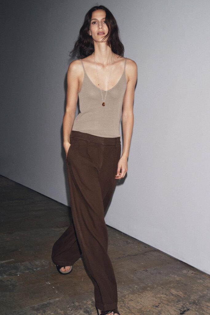 Model wearing casual tank top and flowy chocolate brown pants.