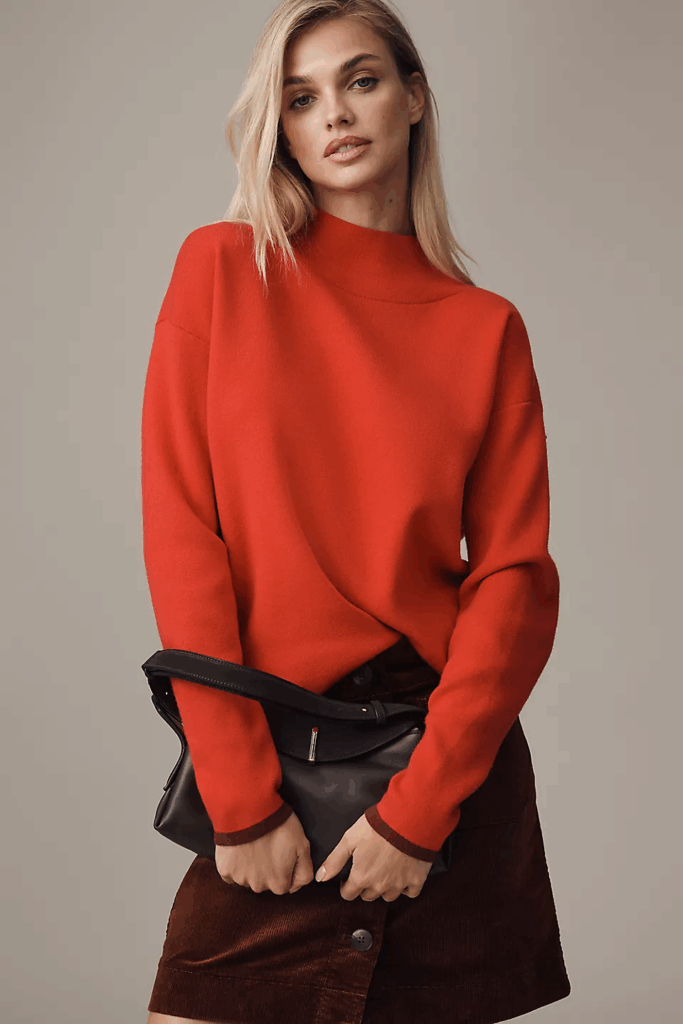 Model wearing red sweater, brown leather skirt  and brown bag.