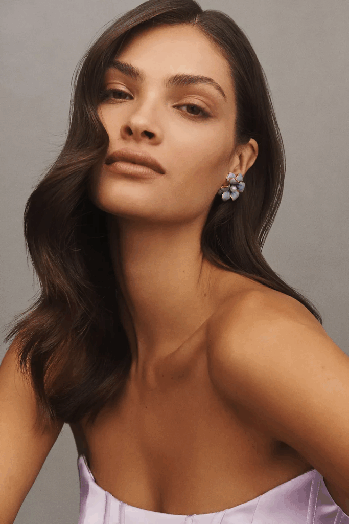 Model wearing pastel light blue floral earrings.