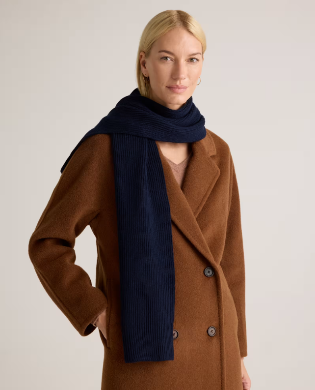 Model wearing a brown coat and navy blue scarf