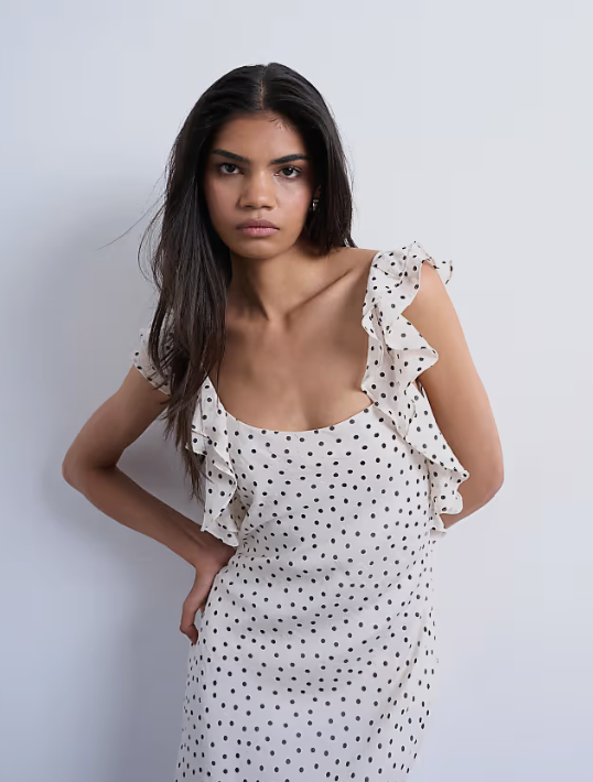 Model wearing black and white feminine polka dot dress