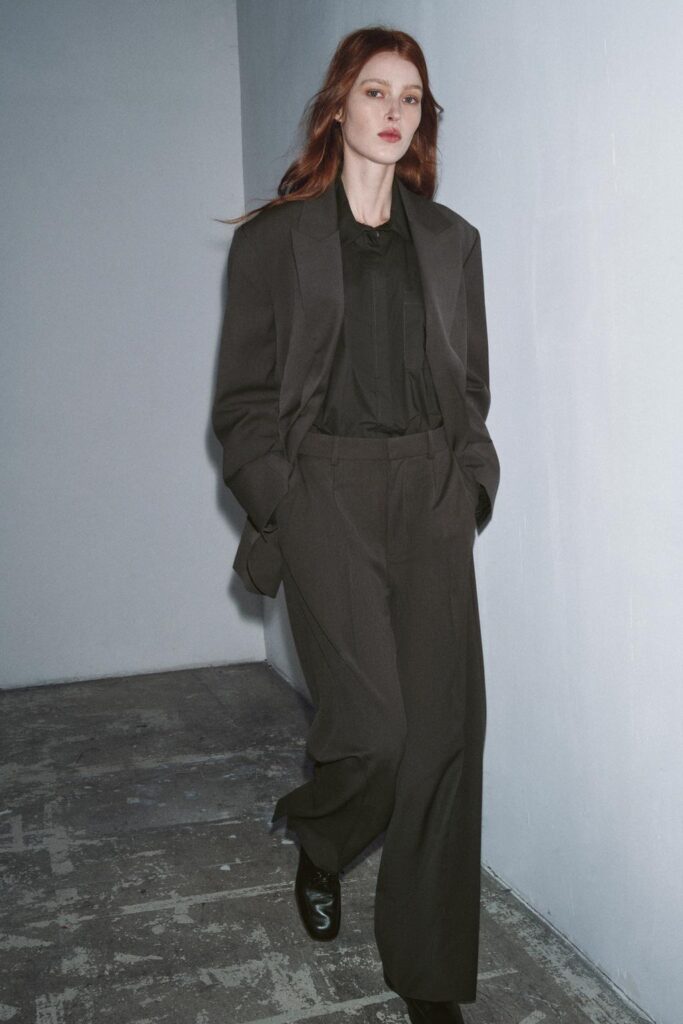 The model is keeping her outfit professional yet festive through an oversized blazer paired with loose trousers. 