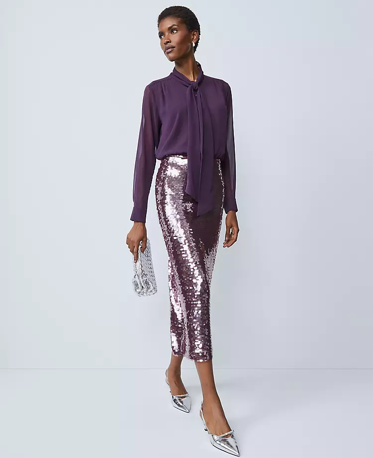 An elegant woman wearing a monochromatic purple outfit, but making it enjoyable through the use of sequins. 