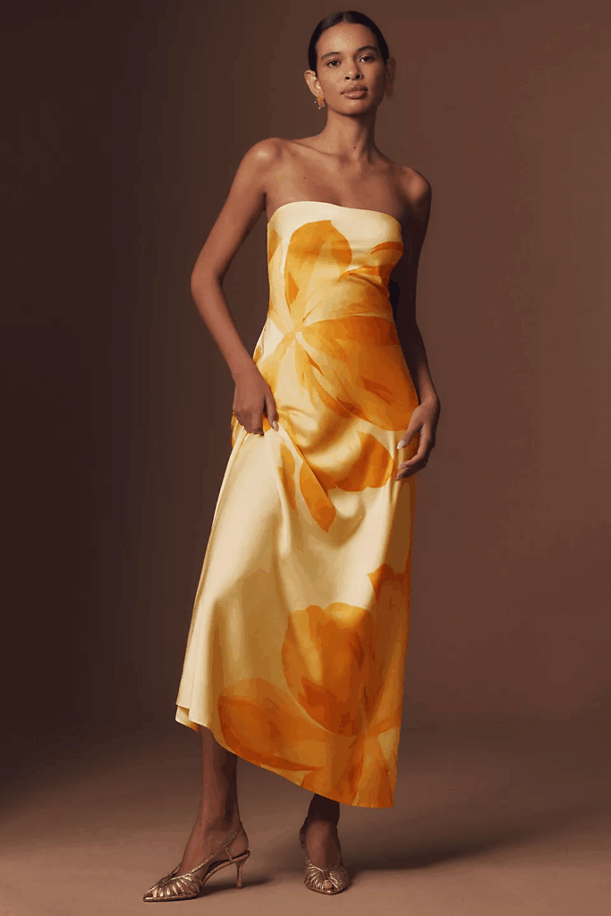 The model is wearing a yellow satin maxi dress for a formal holiday event. 
