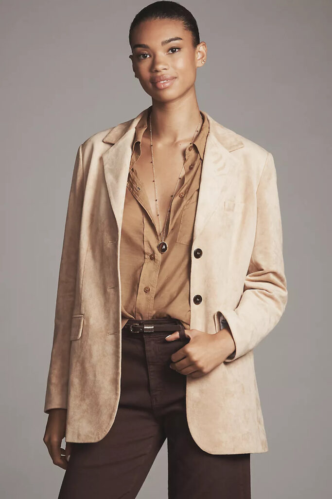 Model styled in a monochromatic brown look unified by an oversized boyfriend blazer.