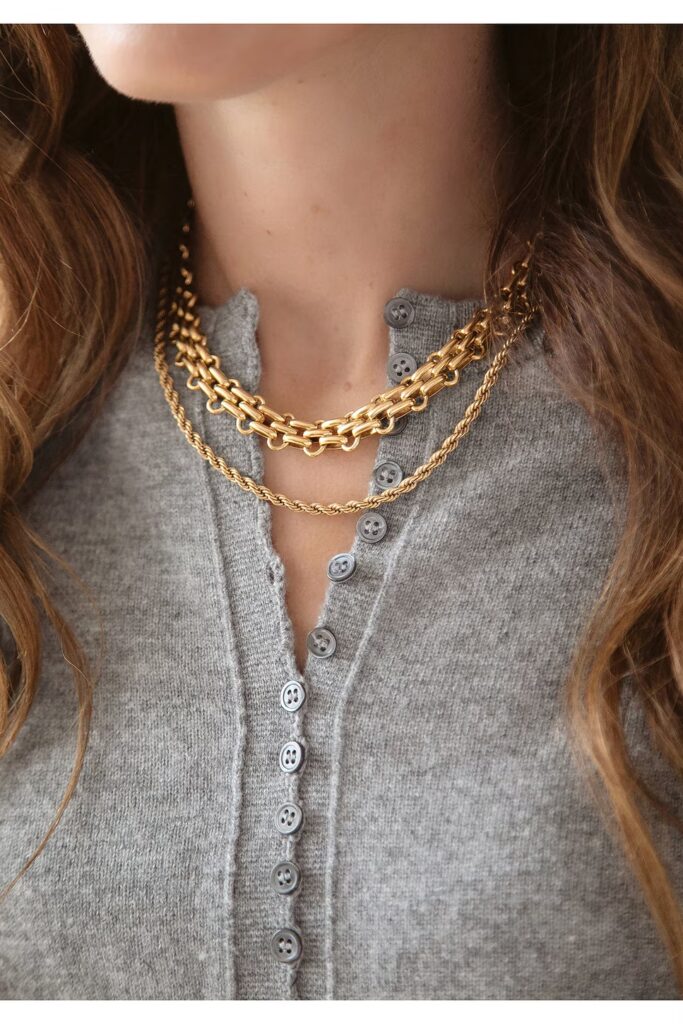 Layered gold chain necklace on a model.