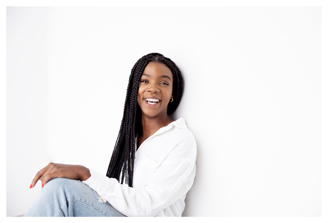 A photoshoot featuring a woman confidently smiling and posing for the camera.