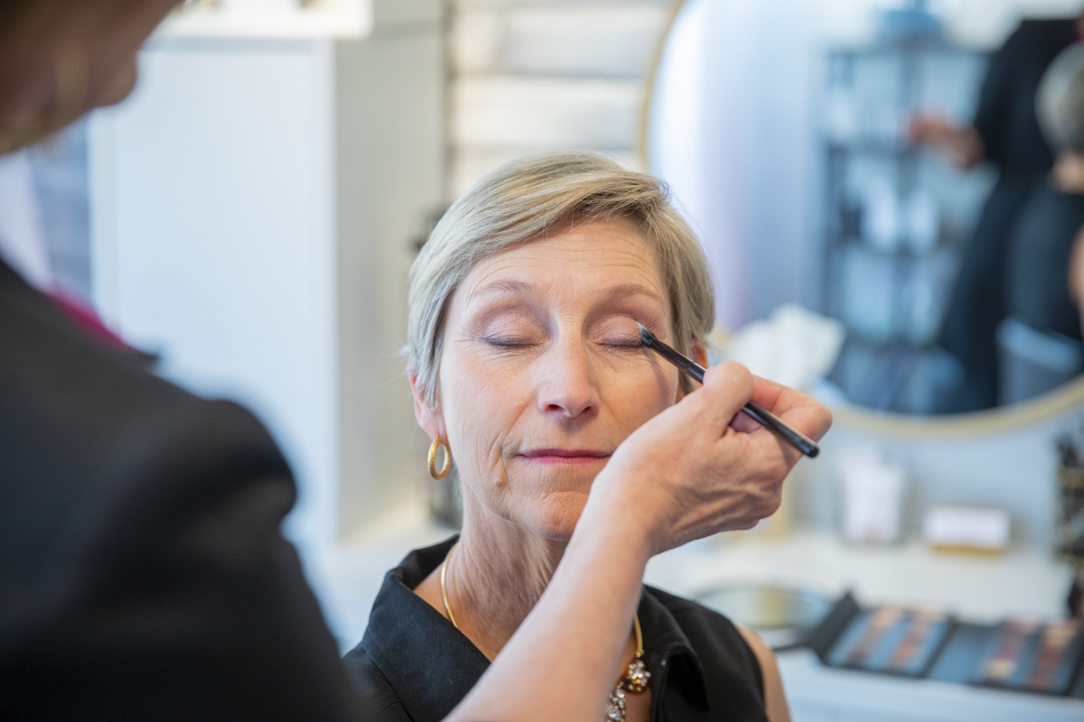 Close-up of a woman getting eye makeup done in the The Honest Image studio.