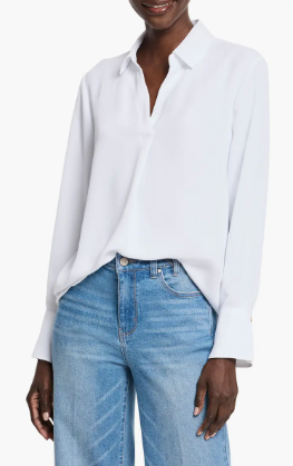 A woman wearing a casual, loose white blouse.