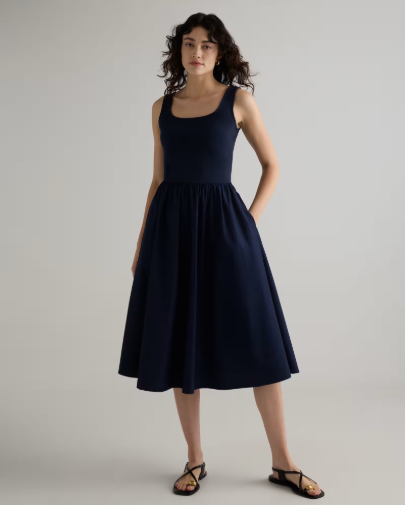 A woman wearing a simple navy blue dress.
