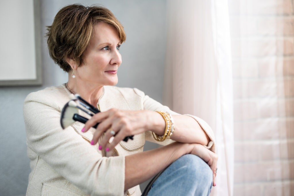 Marla, owner of The Honest Image, seated with her makeup brushes.