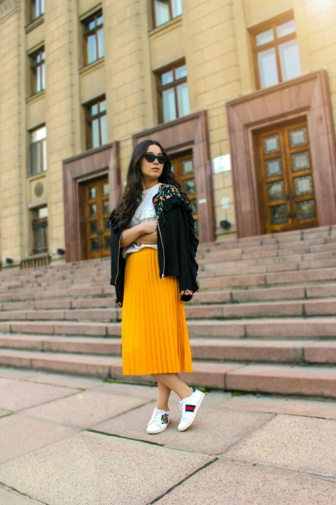 Model wearing a bold outfit with solid colors and mixed textures.