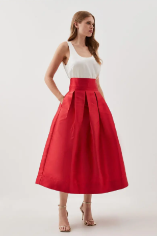 Bold red skirt styled with a neutral, simple blouse to create a soft and chic outfit.