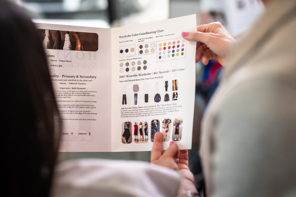 Marla giving personal style advice to a client using a styling guide.