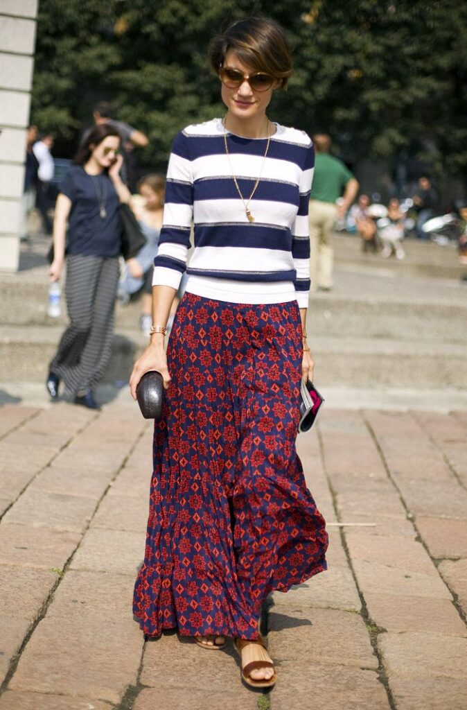 A woman wearing navy floral skirt paired with a navy and white striped top.