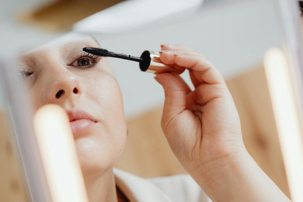 A woman applying water-resistant mascara for summer.