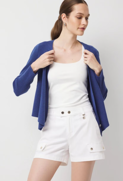 White top and shorts layered with a light blue jacket for a crisp, effortless outfit.