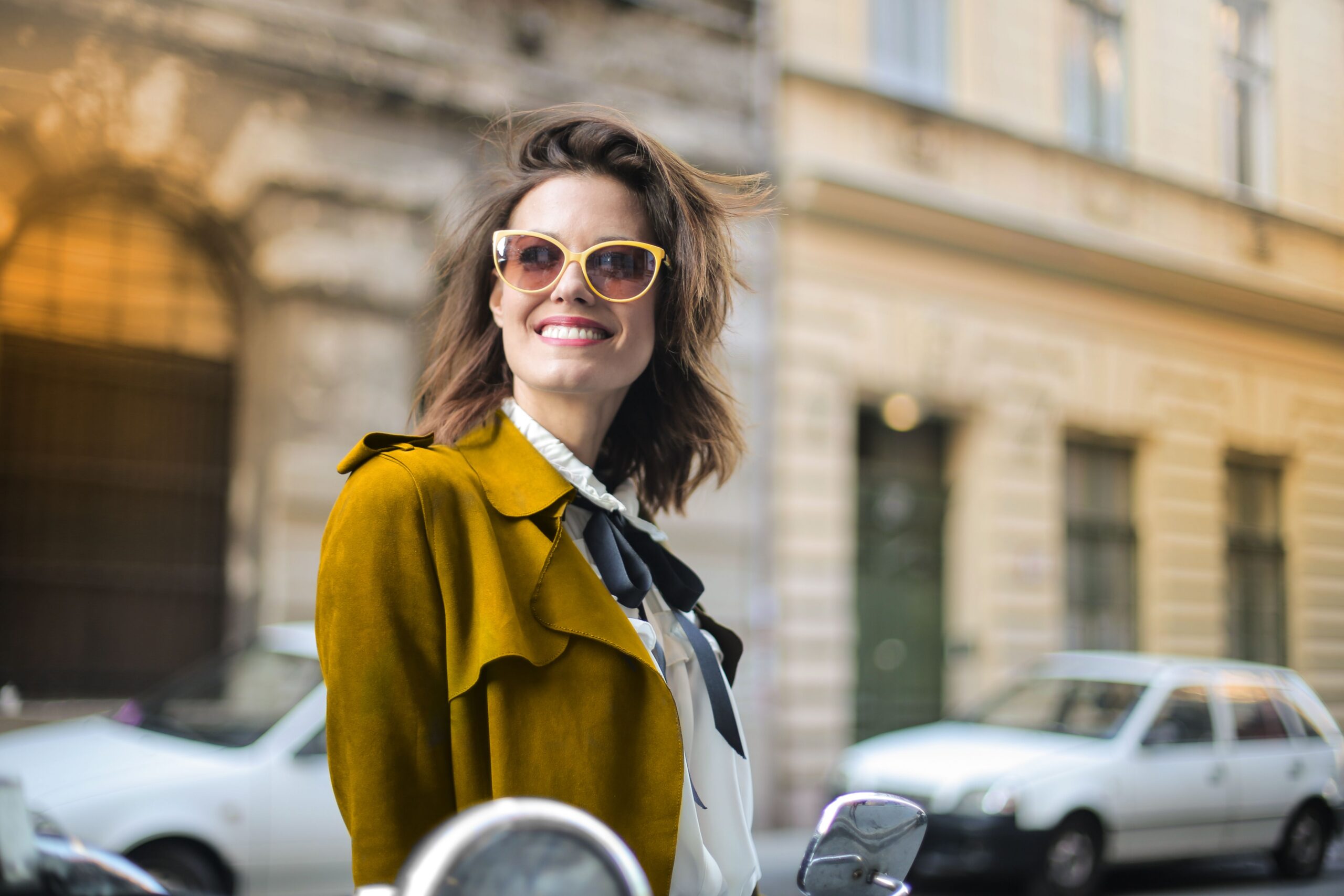 Smiling woman walking along a city street.
