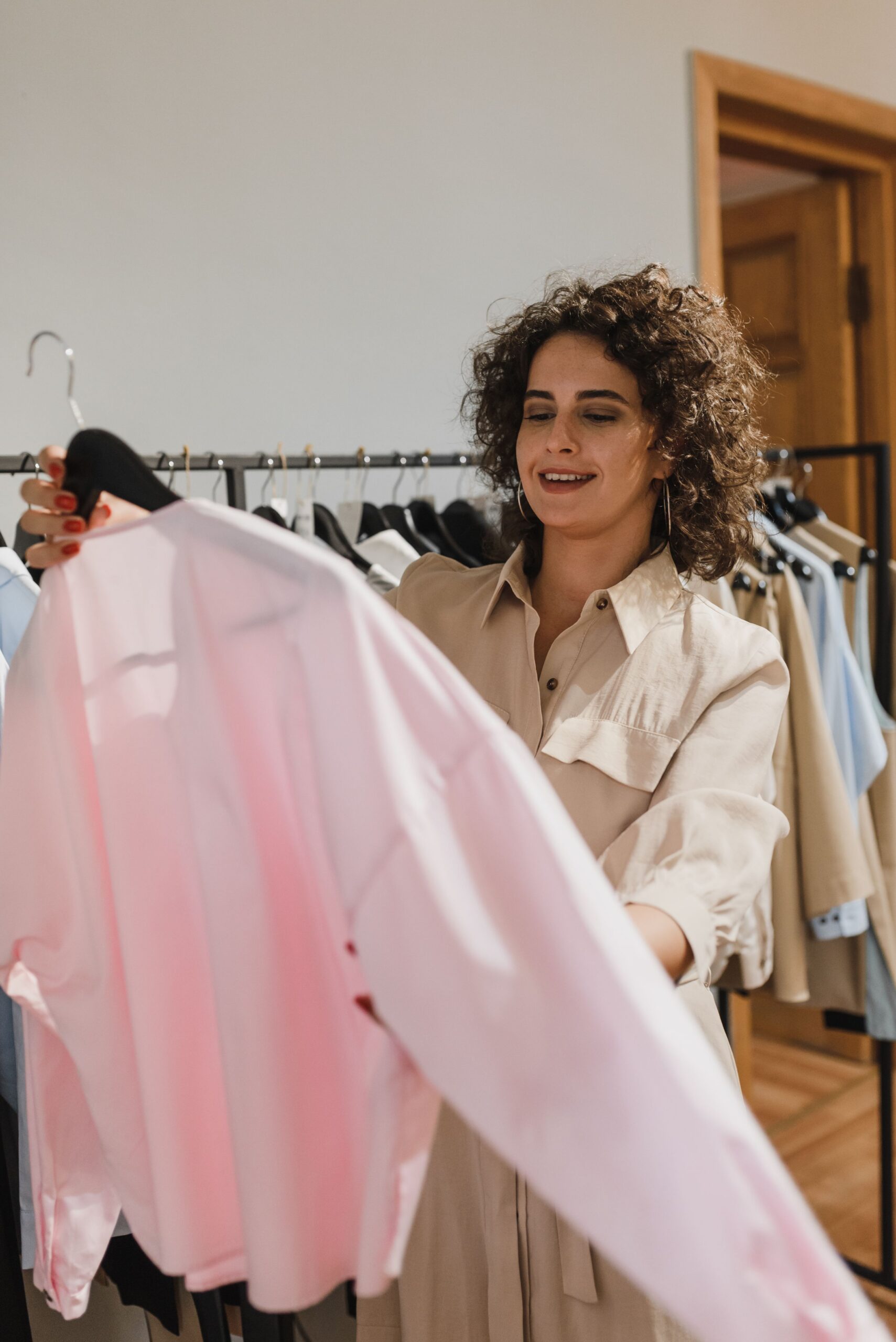 A smiling woman choosing clothes to wear.